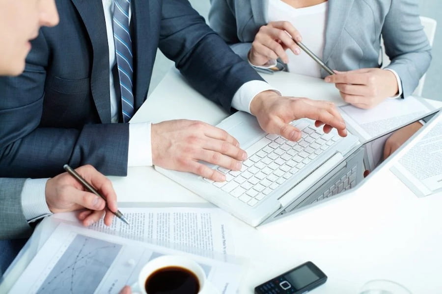 Person sketching a website design on a computer screen.